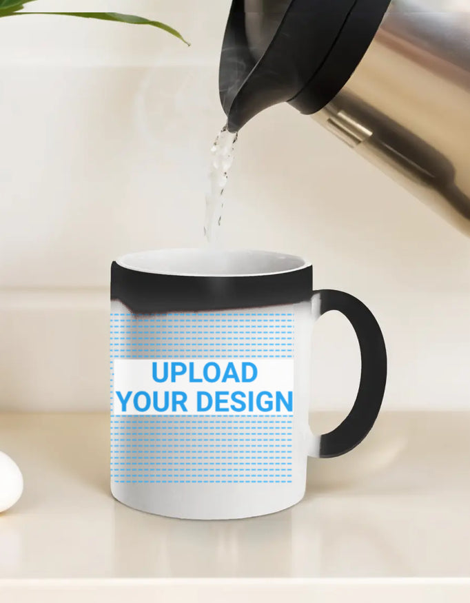 White mug with black handle being filled with water from a kettle on a light background